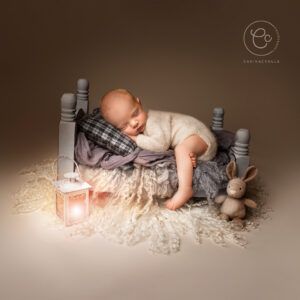 Newborn photo of baby on a miniature bed