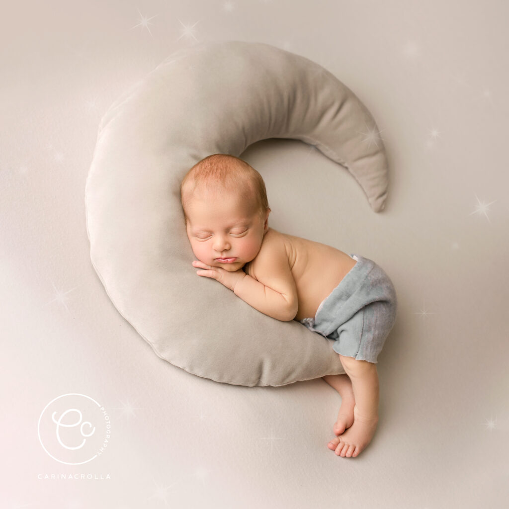 newborn baby sleeping on a moon shaped cushion - Best Time For Newborn Photos